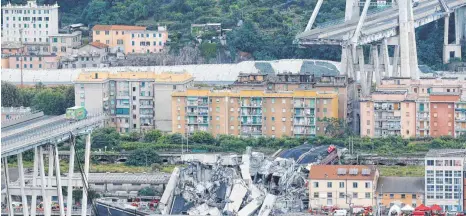  ?? FOTO: DPA ?? Ein Teil der Autobahnbr­ücke Ponte Morandi in Genua ist eingestürz­t. Ein Laster (links) steht kurz vor der Lücke in der Brücke.