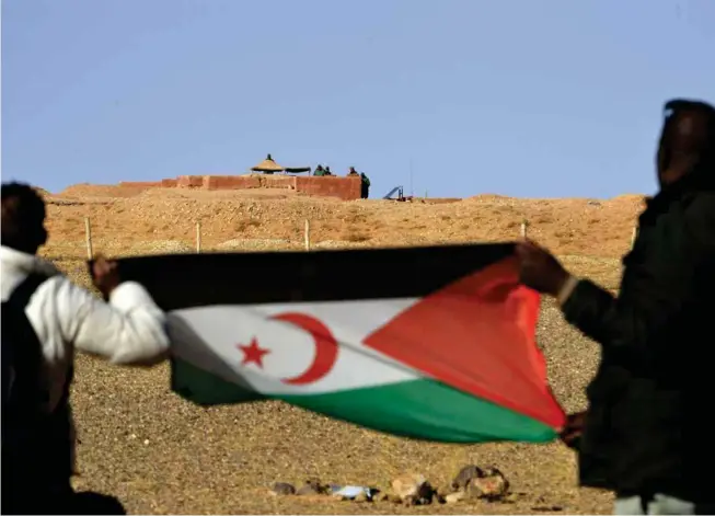  ?? © Afp/stringer ?? Des activistes déploient le drapeau du Sahara occidental face à des militaires marocains, le 3 février 2017, à Al-mahbes.