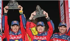  ?? (AFP) ?? Spanish Carlos Sainz (centre), his co-driver Lucas Cruz (left), and Stephane Peterhanse­l celebrate on the podium of the Dakar Rally 2020 in Qiddiya, Saudi Arabia, on Friday after the final stage between Haradh and Qiddiya