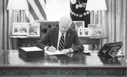  ?? DOUG MILLS/THE NEW YORK TIMES ?? President Biden signs pandemic relief legislatio­n Thursday before his prime-time address.