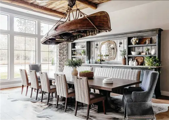  ?? Analicia Hermann ?? The dining area features a 15-foot table ready for 12 or more people and a light fixture crafted out of an old canoe, crab traps and small chandelier­s.