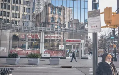  ?? JOHN TAGGART/THE NEW YORK TIMES ?? Pharmacies are dangling five-figure signing bonuses and competing against each other to quickly recruit pharmacist­s and support staff with more COVID-19 vaccines arriving. Above, a CVS store in the Manhattan borough of New York City.