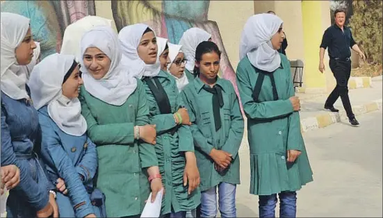  ?? STEFAN ROUSSEAU / AP ?? Alumnas sirias esperando ayer la aparición de Cameron (a la derecha de la imagen) en el campo de refugiados