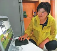  ??  ?? Herder Qiqige monitors her family’s prairie and herds using a computer at home.