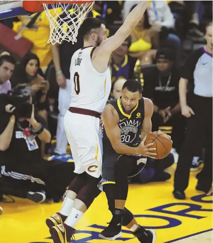  ?? AP PHOTO ?? HE’S LOVING THIS: Warriors guard Stephen Curry ducks under the defense of Cavaliers forward Kevin Love en route to the basket during last night’s Game 2 of the NBA Finals in Oakland, Calif.