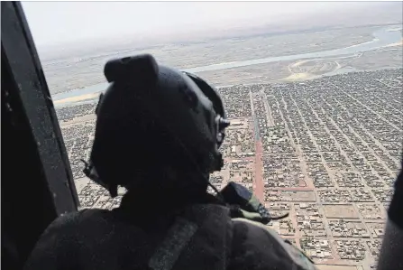  ?? CHRISTOPHE PETIT TESSON ASSOCIATED PRESS FILE PHOTO ?? A French soldier stands inside a military helicopter during a visit by French President Emmanuel Macron to Gao, northern Mali, last year.