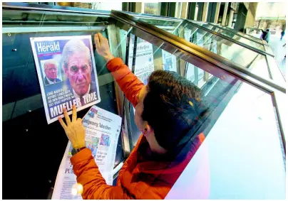  ?? AP ?? William Simms places newspaper front pages from around the nation in display cases at the Newseum yesterday in Washington. Special counsel Robert Mueller closed his long and contentiou­s Russia investigat­ion with no new charges, ending the probe that has cast a dark shadow over Donald Trump’s presidency.