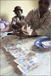  ?? PHOTO: AP ?? Monies are counted at a Stokvel meeting in Nhlazuka, KZN. The savings and loan clubs have been advised to be on alert.