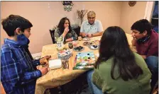  ??  ?? Members of the Kahn family break their fasts after sunset on Thursday as they celebrate Ramadan.