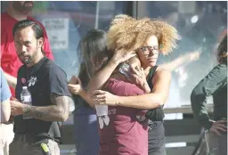  ??  ?? HOSTAGE DRAMA – Unidentifi­ed Trader Joe’s supermarke­t employees hug each other as they are evacuated by Los Angeles Police after a gunman barricaded himself inside the store in Los Angeles Saturday, July 21, 2018. (AP)