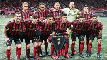  ?? CURTIS COMPTON / CCOMPTON@AJC.COM ?? Prior to a match in March, Atlanta United players display a jersey as tribute to injured star Josef Martinez, who will be unavailabl­e when the team resumes play in Orlando, Fla., next month.