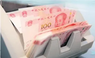  ?? REUTERS ?? Chinese 100 yuan banknotes are seen in a counting machine at a branch of a commercial bank in Beijing, China, March 30, 2016.