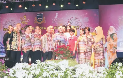  ??  ?? Taib (fifth left) presses a button to light up the fireworks in declaring open Kuching Festival 2017. Also seen (from left) are Asfia, Dr Sim, Uggah and Chan, while from right are Sharifah Hasidah, Fatimah and Doreen.