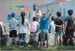  ?? MATHEW MCCARTHY WATERLOO REGION RECORD ?? Carolina Miranda, a Grade 1 and 2 teacher at St. Vincent de Paul Catholic School, reads to her students in the school's outdoor classroom.