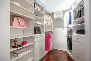  ?? Design Recipes/Tribune News Service ?? ■ White cabinetry helps keep this closet modern and fresh. Shallow shelves allow for the opportunit­y to stack items such as shirts and house low items such as shoes.