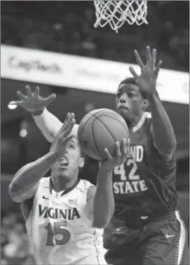  ?? Steve Helber/Associated Press ?? Virginia guard Malcolm Brogdon (15) takes a shot as Cleveland State forward Marlin Mason (42) defends in Charlottes­ville, Va., on Dec. 18.