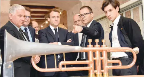  ?? — Reuters ?? Emmanuel Macron (C) looks at a music instrument during a visit at the Compagnons du Devoir house in Rodez, France, on Friday.