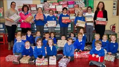  ??  ?? Pupils of Rathangan NS with their collection of Christmas shoe boxes, with Annette Doran of the Christmas Shoe Box Appeal, Nichola Roche, principal, and Sinead McCoy, teacher.