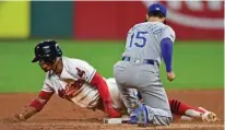  ?? Associated Press ?? Cleveland Indians' Francisco Lindor, left, slides safely into second base for a steal as Kansas City Royals' Whit Merrifield is late with the tag in the fifth inning of a baseball game Friday in Cleveland.