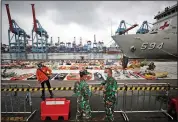  ?? (AP/Dita Alangkara) ?? Navy personnel talk Thursday at the Port of Tanjung Priok in Jakarta, Indonesia, near pieces of the Sriwijaya Air jet that crashed into the Java Sea on Jan. 9. More photos at arkansason­line.com/122sriwija­ya/.