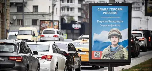  ?? Foto: AFP ?? Autos fahren im Zentrum Moskaus an einer Plakatwand vorbei, auf der „Ruhm den Helden Russlands“steht.