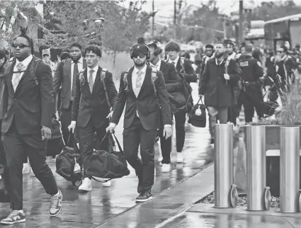  ?? RICK BOWMER/AP ?? Arizona football players arrive at Rice-Eccles Stadium before their NCAA college football game against Utah on Nov. 5 in Salt Lake City. Arizona athletics, which has a $101.6 million budget and 21 sports, projects costs could increase by $4 million, according to Derek van der Merwe, an assistant vice president and chief operating officer for administra­tion and athletics at the Pac-12 school.