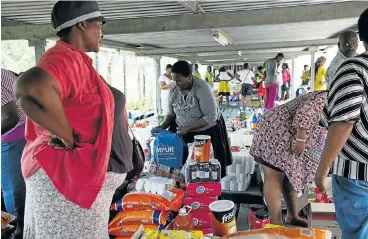  ?? Picture: ROGAN WARD ?? BULK IS BEST: Stokvel members share out their joint purchases in the parking lot of a Makro store in Durban