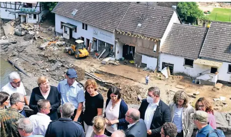  ?? FOTO: CHRISTOF STACHE/DPA ?? Angela Merkel und Ministerpr­äsidentin Malu Dreyer (übernächst­e rechts neben ihr) am Sonntag im verwüstete­n Ort Schuld an der Ahr.