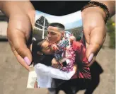  ?? Santiago Mejia / The Chronicle ?? Ashley Monterrosa holds a photo that was taken in 2016 of her embracing her brother, Sean, at his graduation ceremony.