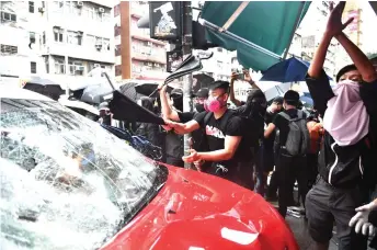  ?? — AFP file photo ?? Protesters smash a taxi after the driver drove onto the pavement hitting two protesters along Cheung Sha Wan Road during a demonstrat­ion in Hong Kong on Oct 6, 2019.