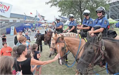  ?? MICHAEL SEARS/MILWAUKEE JOURNAL SENTINEL ?? It’s the 50th anniversar­y of the Wisconsin State Fair’s mounted police patrol. The riders take time out from patrolling the fair to lead the daily parade and afterward people take time to get to know the officers and their horses.