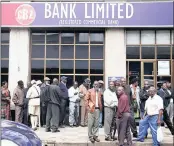  ?? PICTURE: PHILIMON BULAWAYO / REUTERS ?? DAILY GRIND: People queue to draw money outside a bank in Harare yesterday.