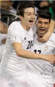  ?? — AFP ?? Iran's Mehdi Taremi (right) celebrates with team mate Sardar Azmoun after scoring against Qatar.