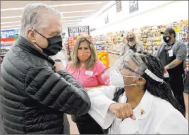  ?? K.M. Cannon Las Vegas Review-journal @Kmcannonph­oto ?? Gov. Steve Sisolak thanks pharmacy manager Trashelle Miro after receiving his COVID-19 vaccinatio­n Thursday at an Albertsons grocery store in southeast Las Vegas.