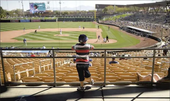  ?? Photograph­s by ?? ADAM GONZALES, 5, is among the 2,341 fans at the Dodgers’ spring home opener against the Rockies at Camelback Ranch in Phoenix on Monday.