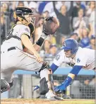  ?? MARK J. TERRILL — THE ASSOCIATED PRESS ?? The Dodgers’ Brian Dozier dives into home before Giants catcher Buster Posey tags him out during Wednesday’s game in Los Angeles.