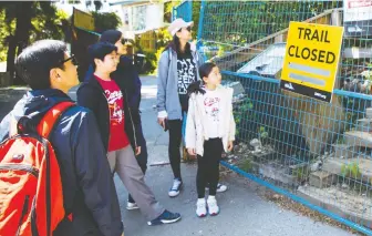  ?? FRANCIS GEORGIAN ?? Gary To and family stand in front of the closed Quarry Rock Trail in Deep Cove on Friday.