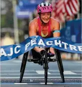  ?? CURTIS COMPTON / CCOMPTON@ AJC.COM ?? Tatyana McFadden hits the finish line to win the women’s wheelchair race in the 48th running of the AJC Peachtree Road Race, her seventh career victory in the Atlanta event.