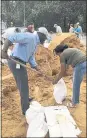  ?? GARY FINEOUT — AP ?? Tallahasse­e Mayor and Democratic gubernator­ial candidate, Andrew Gillum, left, helps Eboni Sipling fill up sandbags in Florida.