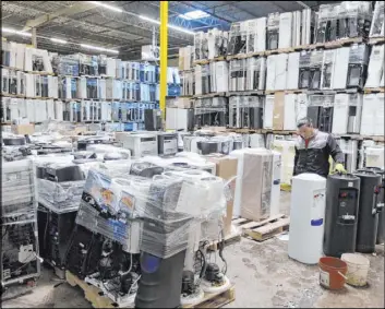  ?? Seth Wenig The Associated Press ?? Water coolers are stacked and ready to be broken down into parts for recycling May 7 at a GDB Internatio­nal warehouse in Monmouth Junction, N.J.