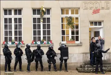  ??  ?? Target: Riot officers swooping on a school in the hunt for the terror suspects