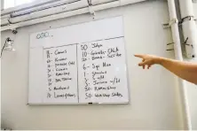  ?? Michael Short / Special to The Chronicle ?? McFlynn points to a whiteboard in his work studio with a long list of restaurant­s for which he is making cooking vessels.