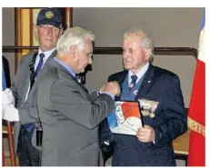  ??  ?? Remise du diplôme d’honneur et de l’insigne de bronze de porte-drapeau à Raymond Plé par Rémy Hamel, vice président CATM.k