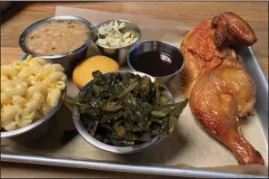  ?? (Arkansas Democrat-Gazette/Eric E. Harrison) ?? Half a smoked chicken is one of three Meat and Three options, with side items including (clockwise from center) collard greens, mac and cheese and Delta white beans, plus Alabama white and house barbecue sauces.
