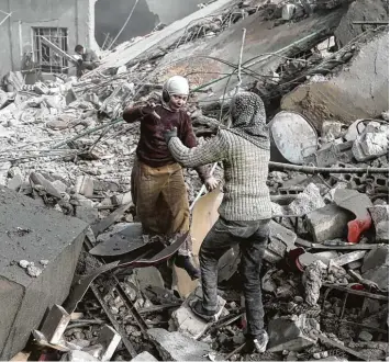  ?? Foto: Abdulmonam Eassa, afp ?? Ein Moment der Freude inmitten von Trümmern und Verzweiflu­ng: Zwei Schwestern stellen fest, dass sie einen Bombenangr­iff auf das Rebellenge­biet Ost Ghuta überlebt haben.