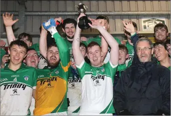  ??  ?? Non-playing Cloughbawn captain Lee Keeley raises the cup after receiving it from Rory Murphy.