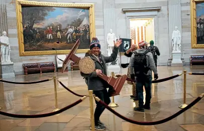  ?? GETTY IMAGES ?? A protester carries the lectern of US Speaker of the House Nancy Pelosi through the rotunda of the US Capitol after a proTrump mob stormed the building as Congress was meeting to certify US President-elect Joe Biden’s victory.