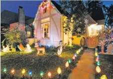  ?? Peter Prato / Special to The Chronicle ?? Holiday decoration­s in a front yard are part of the Christmas tree lane tradition along East Oakland’s Picardy Drive.