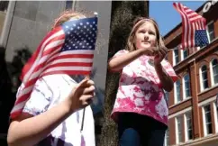  ??  ?? Above: Luci Kapp, 9, and her sister Dori, 7 wave flags to paraders Friday on Market Street during the parade.