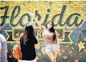  ?? STEPHEN M. DOWELL/ORLANDO SENTINEL ?? Guests take pictures at Disney Springs in Orlando on Wednesday.